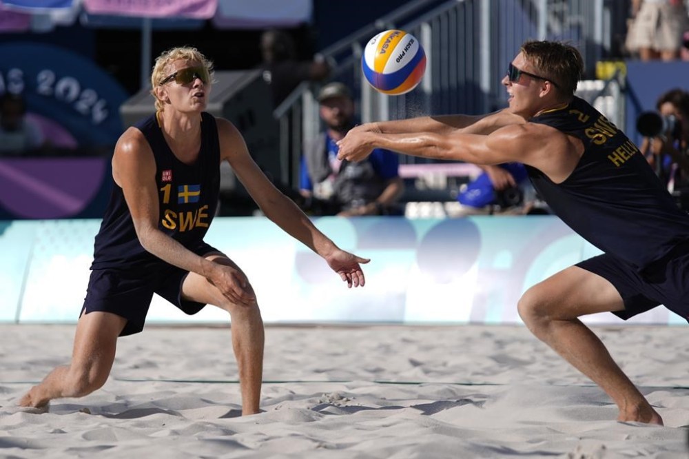 Sweden's David Ahmad, left, watches Jonatan Hellvig return a shot in a quarterfinal beach volleyball match against Brazil at the 2024 Summer Olympics, Tuesday, Aug. 6, 2024, in Paris, France. (AP Photo/Robert F. Bukaty)