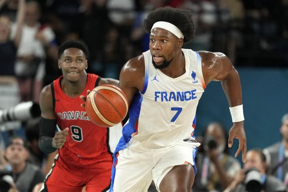 France's Guerschon Yabusele, right, drives the court followed by Canada's RJ Barrett during a men's quarterfinal game at Bercy Arena at the 2024 Summer Olympics, Tuesday, Aug. 6, 2024, in Paris, France. THE CANADIAN PRESS/AP/Mark J. Terrill