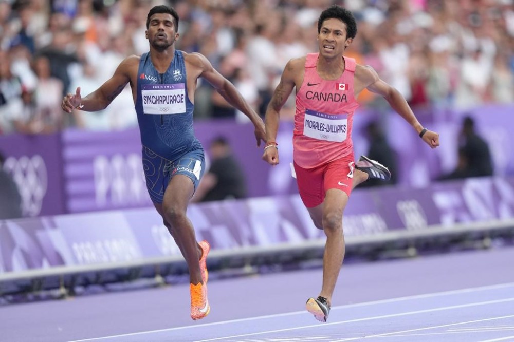 Canada's Christopher Morales-Williams, left, runs in a men's 400-meters heat at the 2024 Summer Olympics, in Saint-Denis, France, Sunday, Aug. 4, 2024. THE CANADIAN PRESS/Nathan Denette