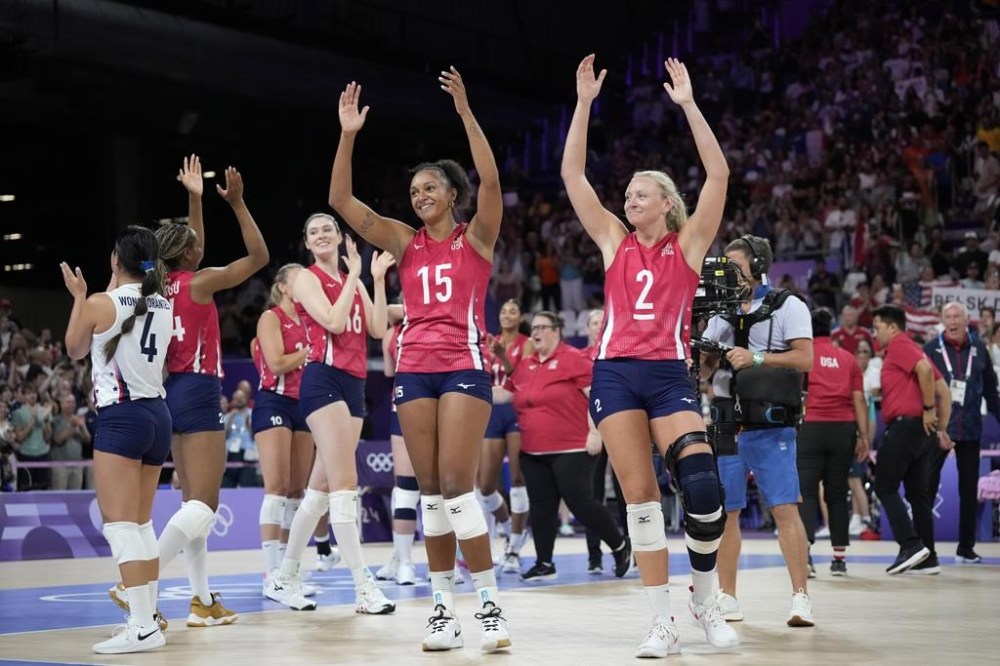 Haleigh Washington, center, and Jordyn Poulter, right, of the United States, celebrate at the end of a women's quarter final volleyball match between the United States and Poland at the 2024 Summer Olympics, Tuesday, Aug. 6, 2024, in Paris, France. (AP Photo/Alessandra Tarantino)