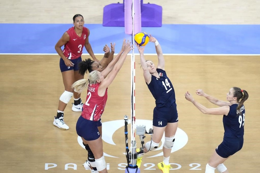 Joanna Wolosz of Poland, right, competes for the ball with Haleigh Washington, second from left, and Jordyn Poulter of the United States during a women's quarter final volleyball match between the United States and Poland at the 2024 Summer Olympics, Tuesday, Aug. 6, 2024, in Paris, France. (AP Photo/Alessandra Tarantino)