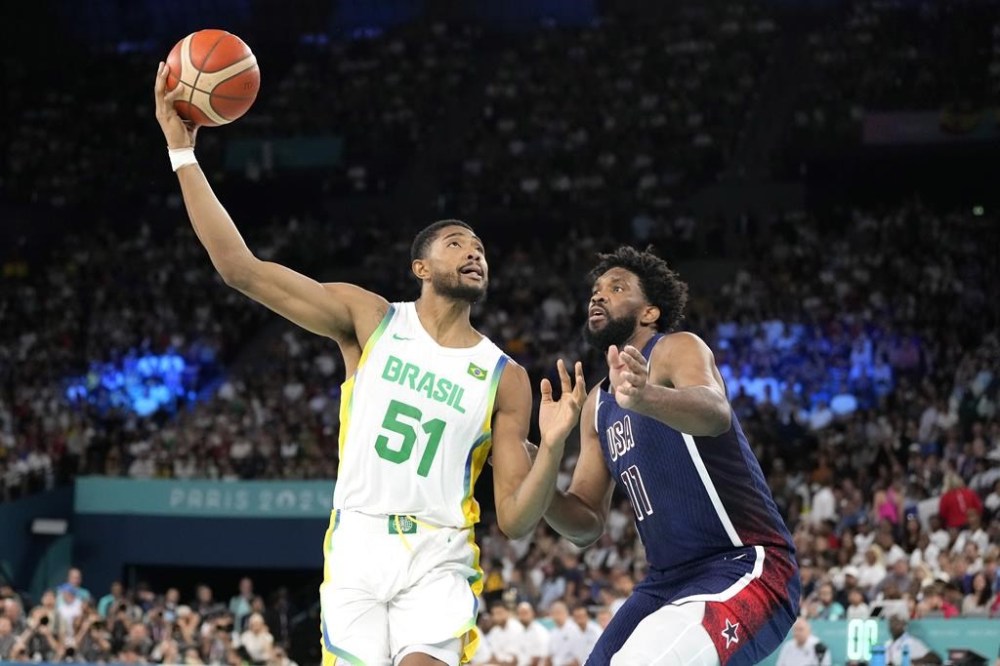 Brazil's Bruno Caboclo, left, shoots as United States' Joel Embiid defends during a men's basketball game at the 2024 Summer Olympics, Tuesday, Aug. 6, 2024, in Paris, France. (AP Photo/Michael Conroy)