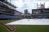 The infield is covered with a tarp before a rain-delayed baseball game between the Arizona Diamondbacks and the Cleveland Guardians in Cleveland, Tuesday, Aug. 6, 2024. (AP Photo/Sue Ogrocki)