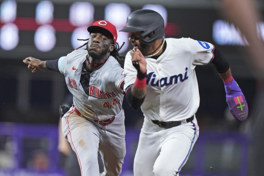 Cincinnati Reds shortstop Elly De La Cruz (44) runs down and tags out Miami Marlins' Derek Hill, after Hill was caught attempting to steal second base during the fourth inning of a baseball game, Tuesday, Aug. 6, 2024, in Miami. (AP Photo/Wilfredo Lee)