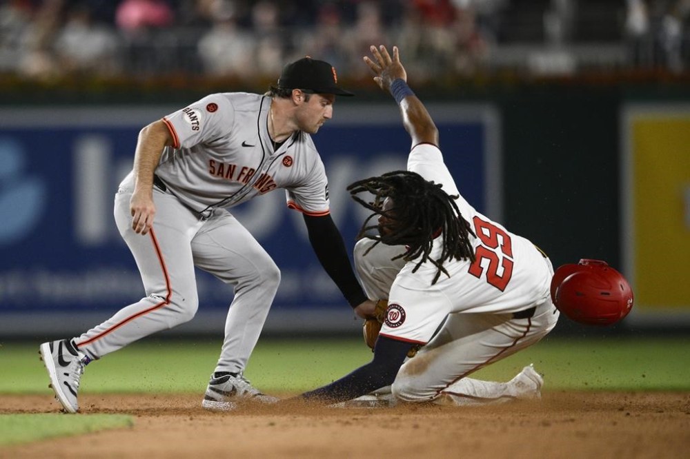 Washington Nationals' James Wood, right, steals second base against San Francisco Giants second baseman Casey Schmitt, left, during the sixth inning of a baseball game, Tuesday, Aug. 6, 2024, in Washington. (AP Photo/Nick Wass)