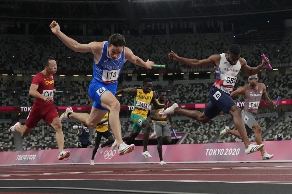 FILE - Filippo Tortu, of Italy, crosses the finish line ahead of Nethaneel Mitchell-Blake, of Britain, to lead his team to a gold medal in the men's 4x100-meter relay at the 2020 Summer Olympics, Aug. 6, 2021, in Tokyo. (AP Photo/David J. Phillip, File)