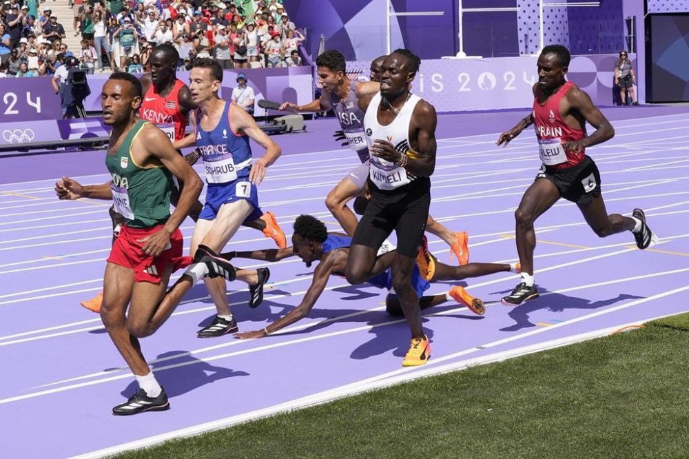 Abdihamid Nur, of the United States, falls during a heat in the men's 5000-meter round at the 2024 Summer Olympics, Wednesday, Aug. 7, 2024, in Saint-Denis, France. (AP Photo/Bernat Armangue)