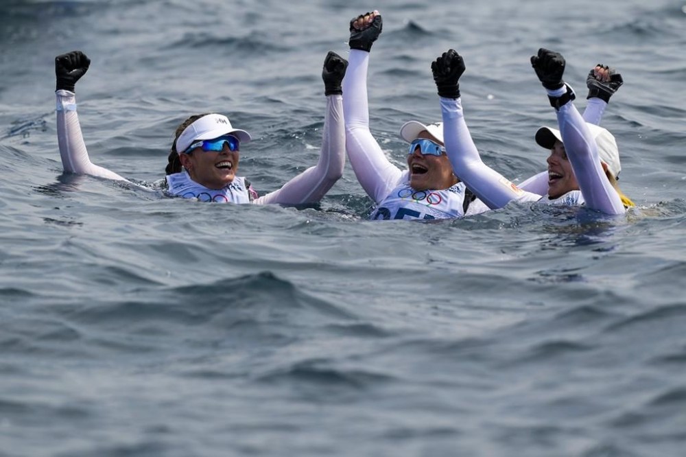 From left, three medalists Line Flem Hoest of Norway, bronze medal, Anne-Marie Rindom of Denmark, silver medal, and Marit Bouwmeester of the Netherlands, gold medal, celebrate at the end of the ILCA 6 women's dinghy class final race during the 2024 Summer Olympics, Wednesday, Aug. 7, 2024, in Marseille, France. (AP Photo/Carolyn Kaster)