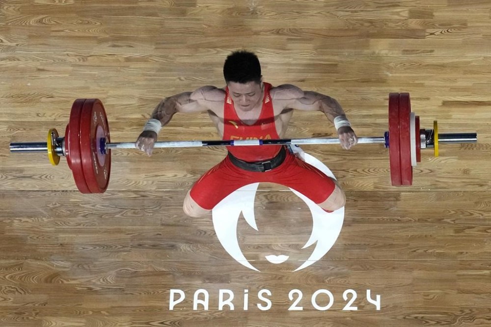 Li Fabin of China competes during the men's 61kg weightlifting event at the 2024 Summer Olympics, Wednesday, Aug. 7, 2024, in Paris, France. (AP Photo/Dita Alangkara,Pool)