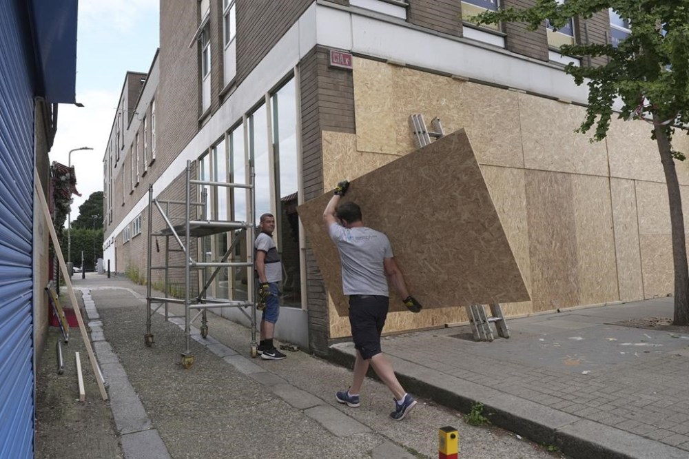 Windows are boarded up ahead of an anti-immigration protest in North Finchley, London, England, Wednesday, Aug. 7, 2024. (Jordan Pettitt/PA via AP)