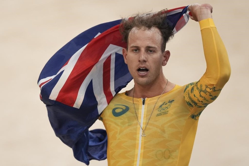Sam Welsford of Australia celebrates winning the gold medal in the men's team pursuit event, at the Summer Olympics, Wednesday, Aug. 7, 2024, in Paris, France. (AP Photo/Thibault Camus)