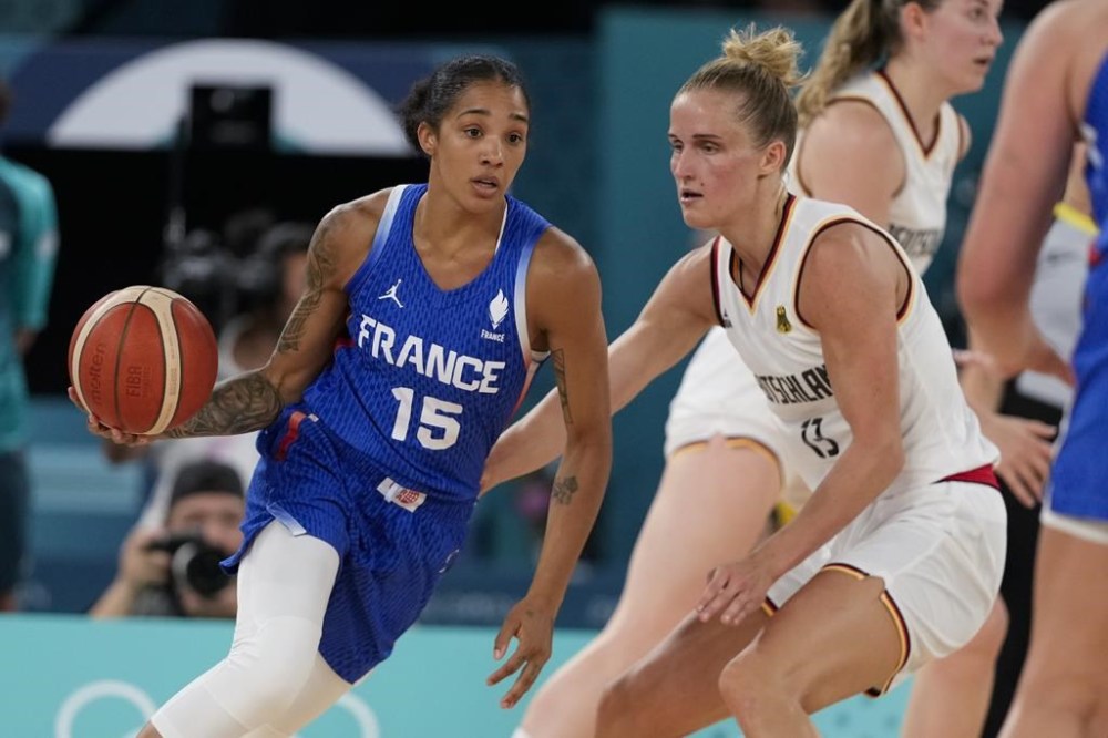 Gabby Williams (15), of France, drives on Leonie Fiebich (13), of Germany, during a women's quarterfinal game at Bercy Arena at the 2024 Summer Olympics, Wednesday, Aug. 7, 2024, in Paris, France. (AP Photo/Mark J. Terrill)
