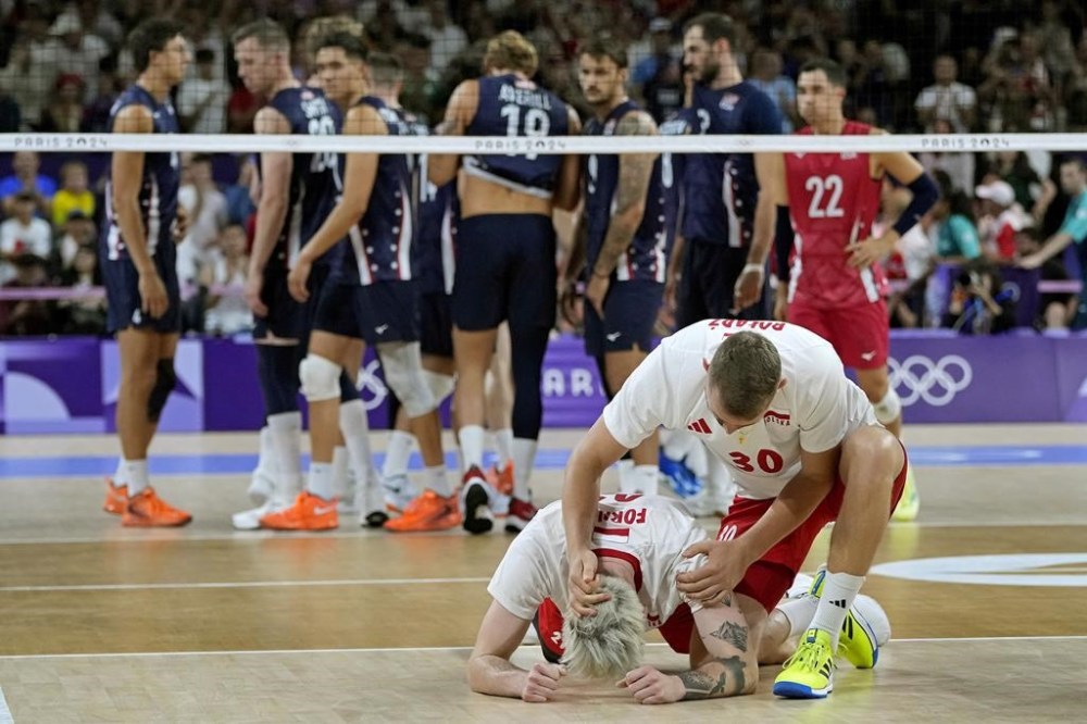 Tomasz Fornal, center left, and Bartlomiej Boladz (30), of Poland, celebrate after winning their semifinal men's volleyball match against the United States at the 2024 Summer Olympics, Wednesday, Aug. 7, 2024, in Paris, France. (AP Photo/Dolores Ochoa)