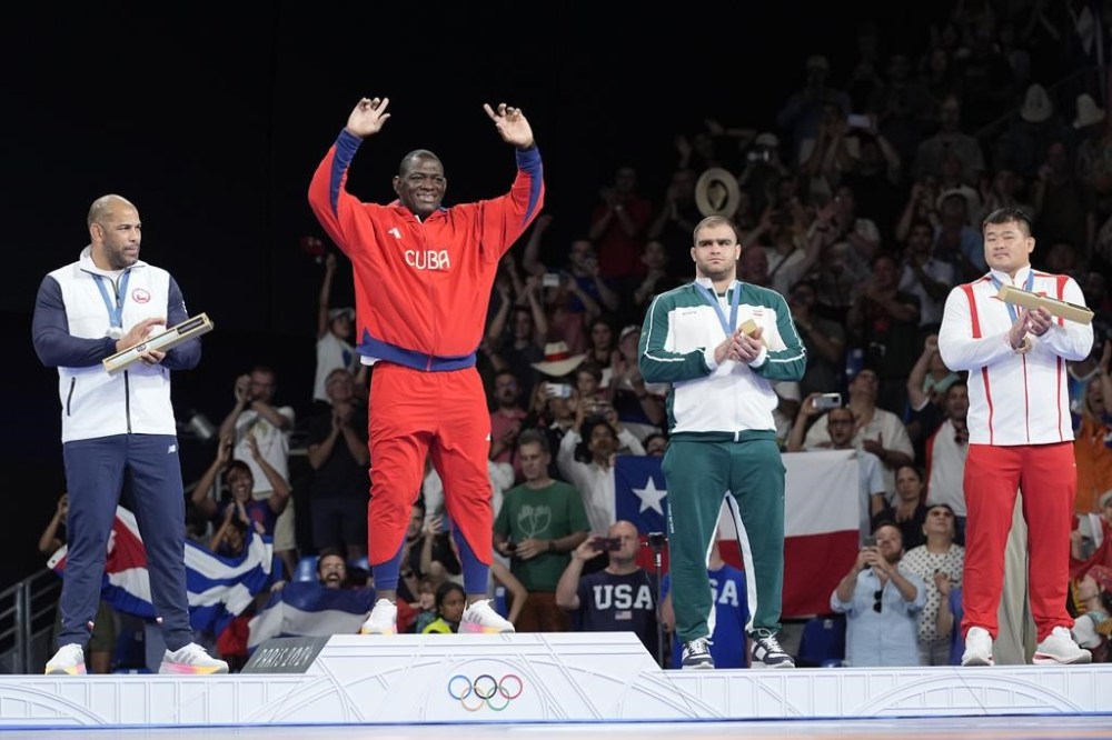 Medalists, from left, Chile's Yasmani Acosta Fernandez, silver, Cuba's Mijain Lopez Nunez, gold, Iran's Amin Mirzazadeh, China's Meng Lingzhe, bronze, pose for photographers during the medal ceremony for men's Greco-Roman 130kg wrestling, at Champ-de-Mars Arena, during the 2024 Summer Olympics, Tuesday, Aug. 6, 2024, in Paris, France. (AP Photo/Eugene Hoshiko)