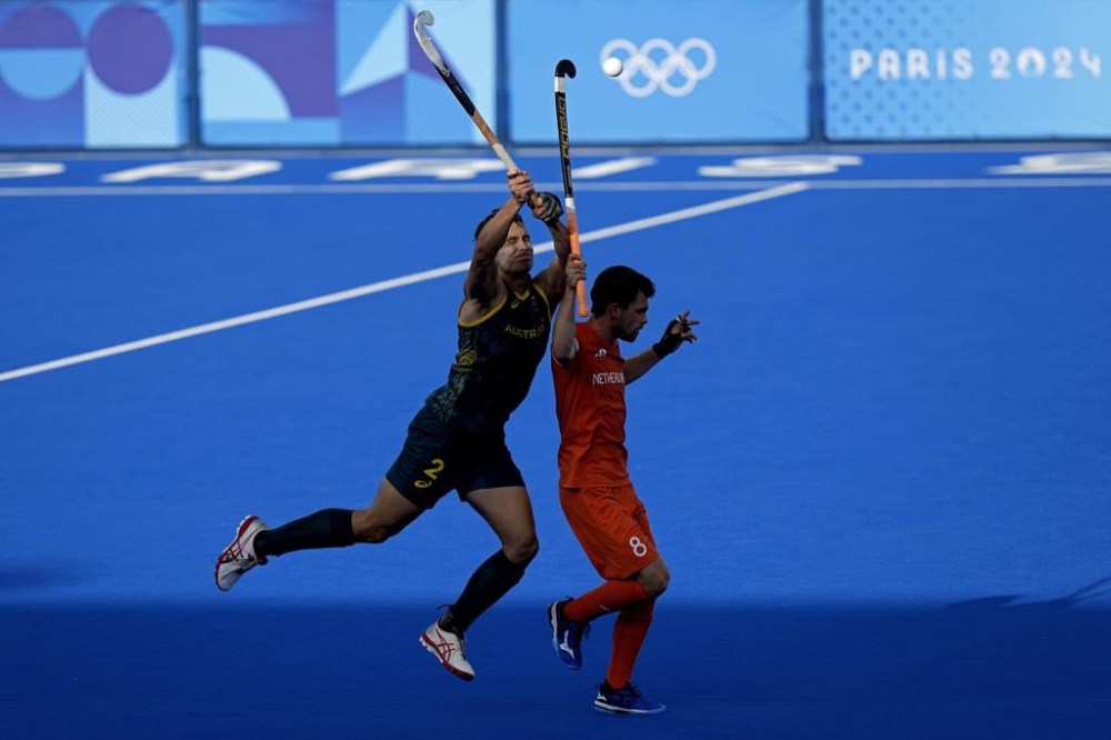 Australia's Thomas Craig, left, and Netherlands' Thierry Brinkman jump to reach for the ball during the men's quarterfinal field hockey match between Australia and Netherlands at the Yves-du-Manoir Stadium during the 2024 Summer Olympics, Sunday, Aug. 4, 2024, in Colombes, France. (AP Photo/Aijaz Rahi)