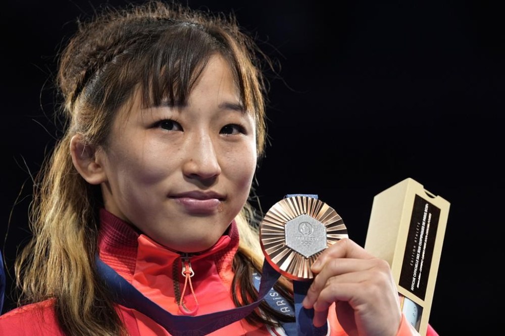 Japan's Yui Susaki celebrates with her bronze medal during the victory ceremony for women's freestyle 50kg wrestling, at Champ-de-Mars Arena, during the 2024 Summer Olympics, Wednesday, Aug. 7, 2024, in Paris, France. (AP Photo/Eugene Hoshiko)