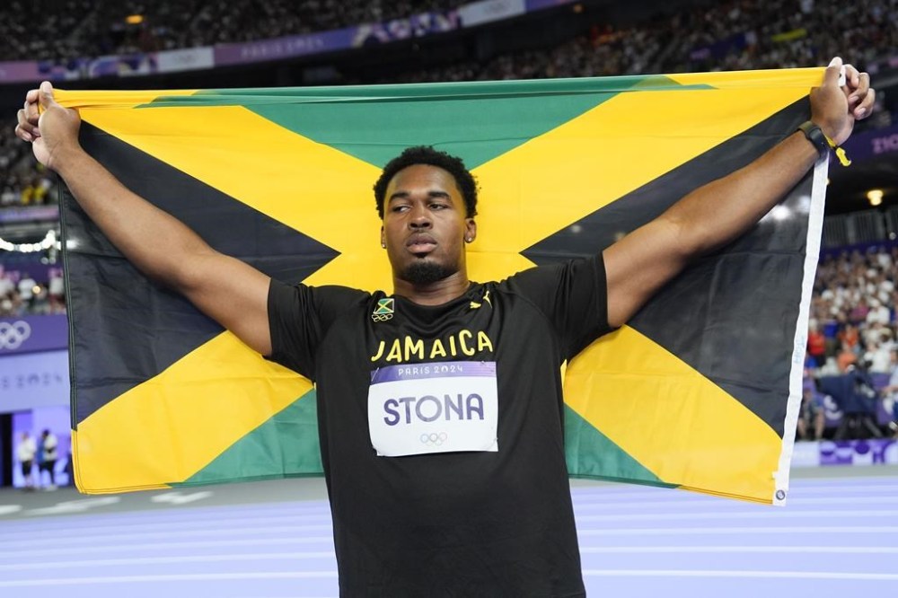 Roje Stona, of Jamaica, celebrates after winning the men's discus throw final at the 2024 Summer Olympics, Wednesday, Aug. 7, 2024, in Saint-Denis, France. (AP Photo/Matthias Schrader)