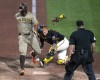 San Diego Padres' Xander Bogaerts, left, knocks the ball out of the glove of Pittsburgh Pirates catcher Yasmani Grandal, center, to score from third on a sacrifice fly by Jackson Merrill off relief pitcher Colin Holderman during the tenth inning of a baseball game in Pittsburgh, Wednesday, Aug. 7, 2024. (AP Photo/Gene J. Puskar)