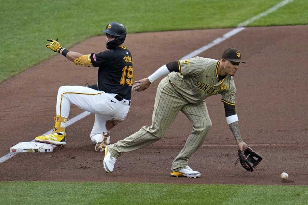Pittsburgh Pirates' Jared Triolo (19) slides safely into third on a throwing error by San Diego Padres third base Manny Machado, right, during the second inning of a baseball game in Pittsburgh, Wednesday, Aug. 7, 2024. (AP Photo/Gene J. Puskar)