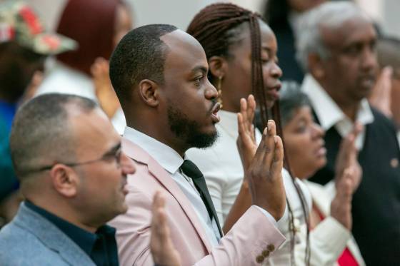 Henry Amogu, 31, (centre) participates in the oath of Citizenship with his wife Oreo Amogu, 31, (right). The couple immigrated from Nigeria to Canada. (Brook Jones / Free Press)