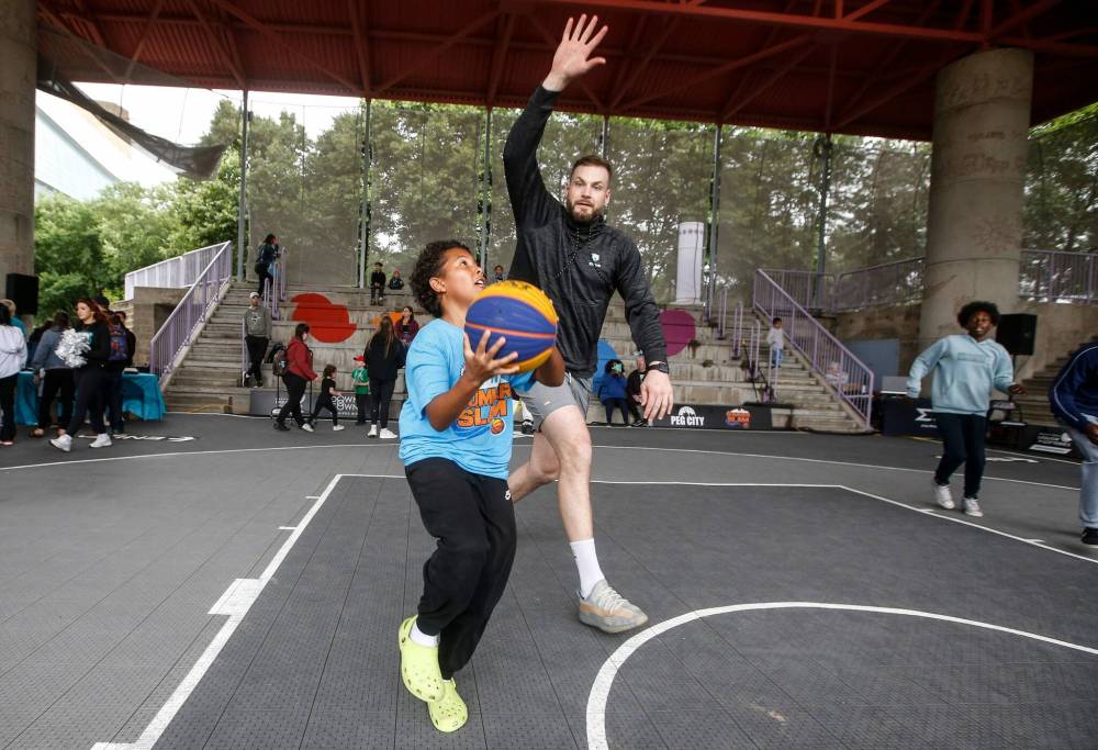 JOHN WOODS / FREE PRESS
Chad Posthumus, centre with the Sea Bears, plays ball with Jace Guilbert at the Canada Day celebrations at the Forks, Monday.