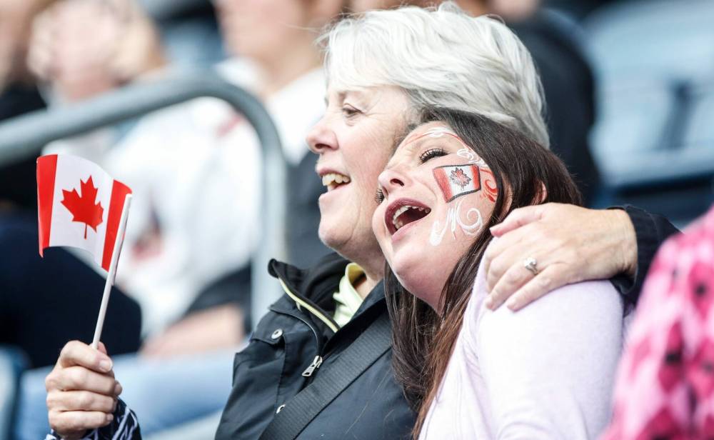 JOHN WOODS / FREE PRESS
Joanne Deezar and niece Genelle D’eschambault sing along while Catie St. Germain performs in the Canada Day celebrations at Princess Auto stadium Monday.