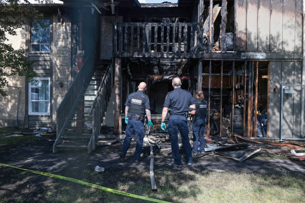 Ruth Bonneville / Free Press Files
Forensic officers investigate at the scene of a fire in a townhouse on Keewatin Street last Wednesday.