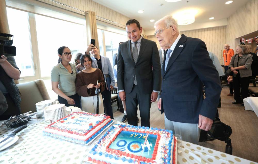 Ruth Bonneville / Free Press
                                Earl with Premier Wab Kinew as he cuts into his birthday cake, Tuesday.