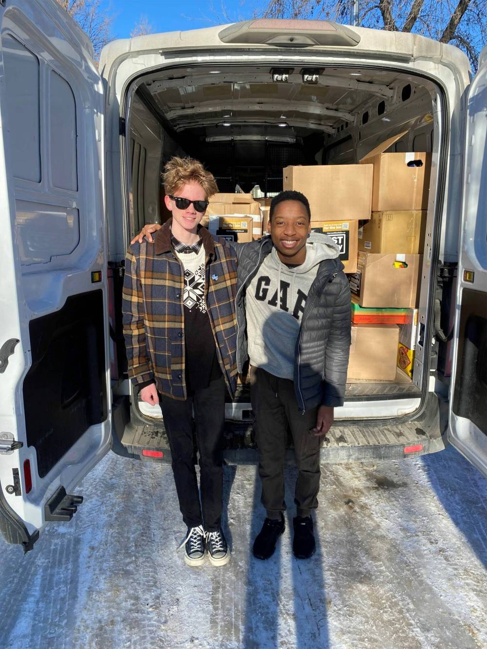 SUPPLIED
Longtime volunteers and best friends James Lesyk (left) and Ndidi Wamy stand beside the food they helped collect for charity from nine different schools.