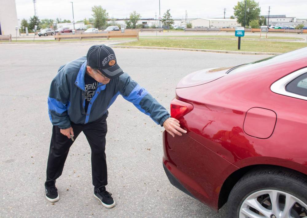 MIKE THIESSEN / FREE PRESS FILES
Robert Shuster points out the damage sustained to his car as a result of the hailstorm.