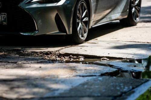 MIKAELA MACKENZIE / FREE PRESS
                                A car drives around a pothole on Campbell Street (between Academy Road and Wellington Crescent) on Monday, July 8, 2024. For Joyanne story.