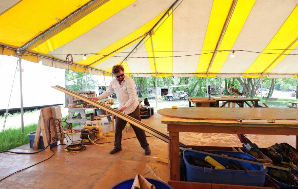 A carpenter works on site in preparation for this year's Folk Festival. (Ruth Bonneville / Free Press)