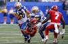 Winnipeg Blue Bombers' Nic Demski (10) runs for the first down as Calgary Stampeders' Malcolm Thompson (19) hangs on during first half CFL action in Winnipeg, Friday, July 12, 2024. THE CANADIAN PRESS/John Woods