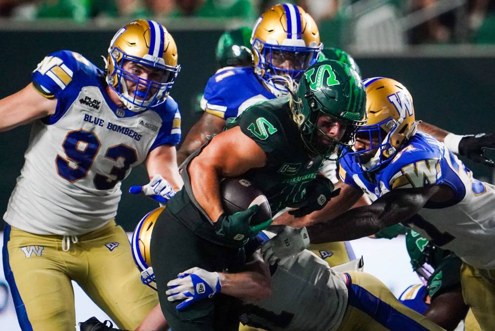 HEYWOOD YU / THE CANADIAN PRESS FILES
The Blue Bombers defence wraps up Roughriders running back AJ Ouellette on Friday night in July.