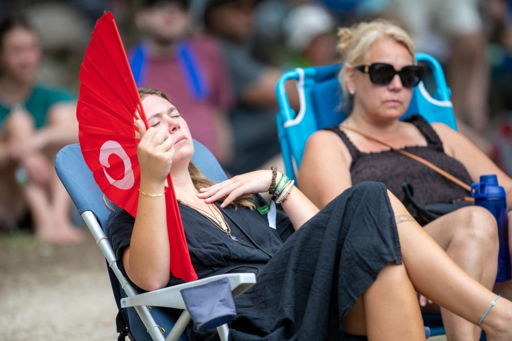 BROOK JONES / FREE PRESS
Folk Fest goer Grace Wallace, 22, who is from Lockport, Man., keeps cool on a hot summer day by waving a giant hand fan as she listens to Steph Strings perform on the Little Stage In The Forest Sunday. Wallace has been attending Folk Fest since she was three-months-old.