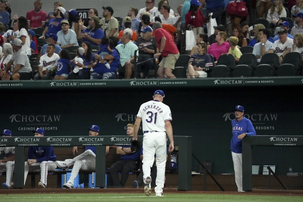 Texas Rangers starting pitcher Max Scherzer (31) leaves the field as pitching coach Mike Maddux, right, look on after Scherzer gave up 4 runs in the second inning of a baseball game Saturday, July 20, 2024, in Arlington, Texas. Scherzer did not return. (AP Photo/Jeffrey McWhorter)