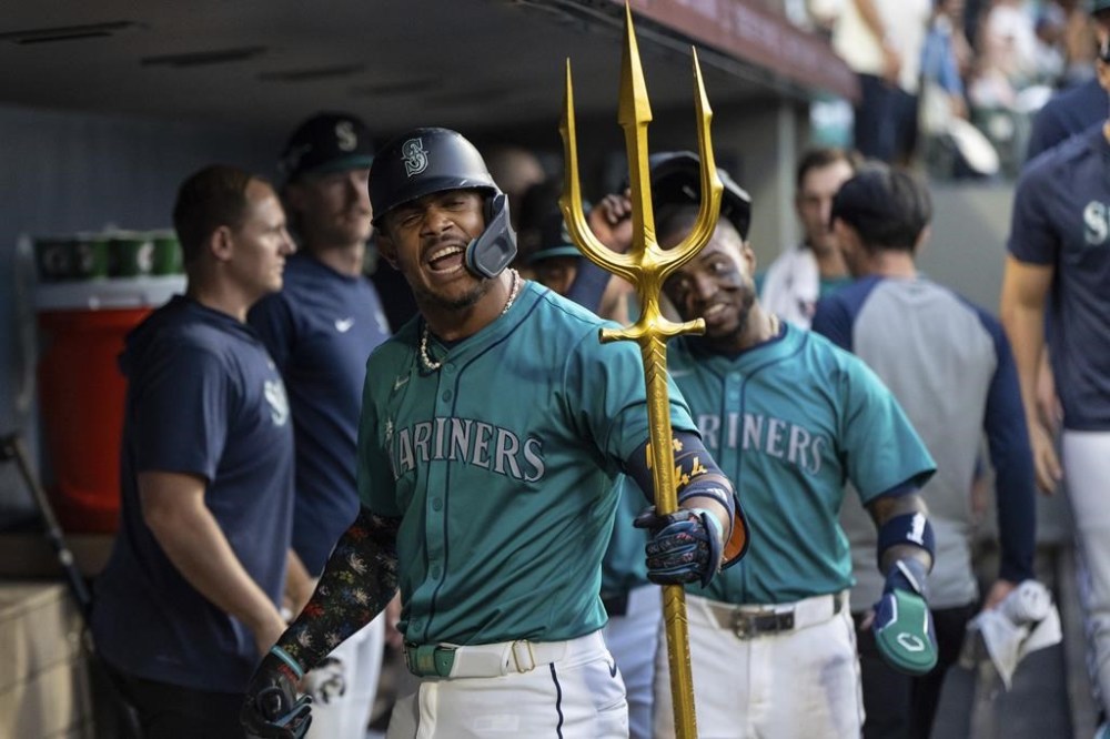 Seattle Mariners' Julio Rodriguez celebrates with a trident in the dugout after hitting a two-run home run during the sixth inning of a baseball game against the Houston Astros, Saturday, July 20, 2024, in Seattle. (AP Photo/Stephen Brashear)