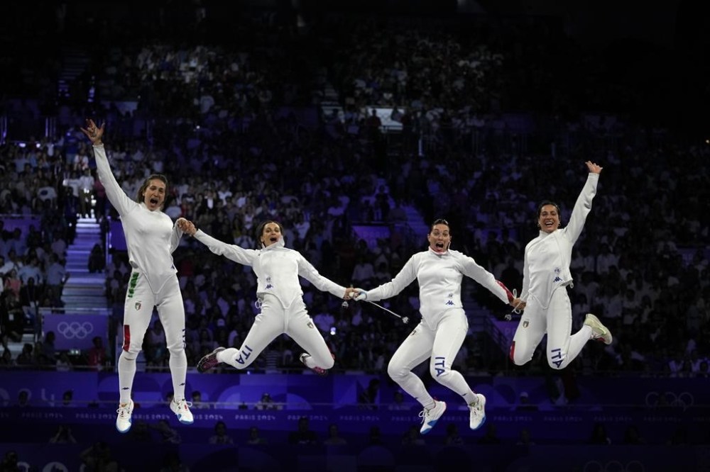 Italy's Alberta Santuccio, second right, celebrates with her teammates Rossella Fiamingo, second left, Giulia Rizzi, left, and Mara Navarria after winning the women's team Epee final match against France during the 2024 Summer Olympics at the Grand Palais, Tuesday, July 30, 2024, in Paris, France. (AP Photo/Andrew Medichini)
