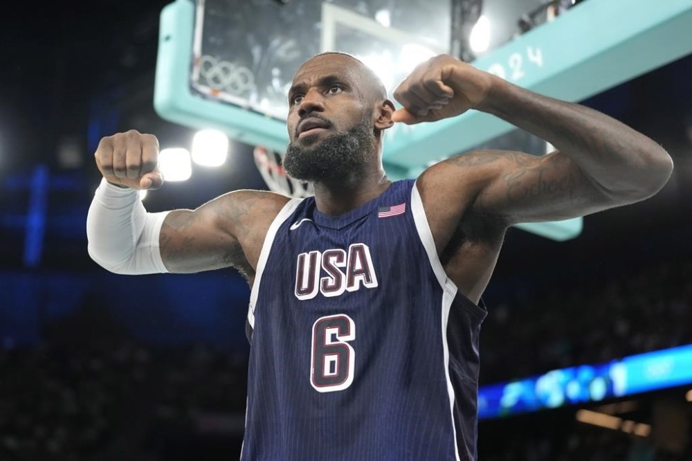 United States' LeBron James flexes after scoring during a men's basketball game against Brazil at the 2024 Summer Olympics, Tuesday, Aug. 6, 2024, in Paris, France. (AP Photo/Michael Conroy)