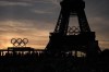 Spectators watch a quarterfinal beach volleyball match between Australia and Switzerland at sunset at Eiffel Tower Stadium at the 2024 Summer Olympics, Tuesday, Aug. 6, 2024, in Paris, France. (AP Photo/Robert F. Bukaty)