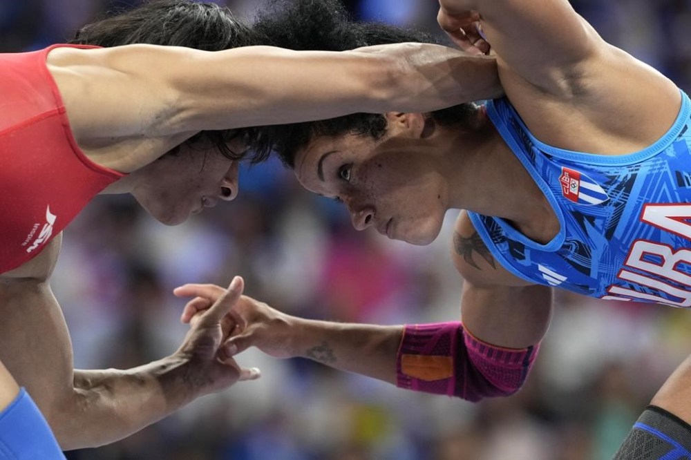 India's Vinesh Vinesh and Cuba's Yusneylys Guzman, right, compete during their women's freestyle 50kg wrestling semifinal match, at Champ-de-Mars Arena, during the 2024 Summer Olympics, Tuesday, Aug. 6, 2024, in Paris, France. (AP Photo/Eugene Hoshiko)