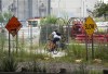 A cyclist negotiates a bike path through the Don River Revitalization and Gardiner Expressway Demolition projects in Toronto on Thursday August 17, 2023. The City of Toronto says it has laid bylaw charges against two companies that illegally left a construction bin on the road where a 24-year-old cyclist died after being struck by a dump truck last month. THE CANADIAN PRESS/Frank Gunn
