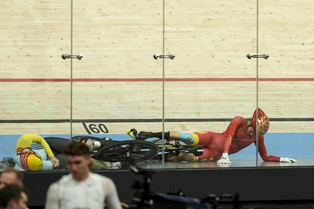 Liying Yuan of China, right, lies on the track after crashing during the women's keirin event, at the Summer Olympics, Thursday, Aug. 8, 2024, in Paris, France. (AP Photo/Ricardo Mazalan)