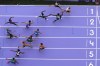 Athletes exchange the baton during a men's 4x400-meter relay heat at the 2024 Summer Olympics, Friday, Aug. 9, 2024, in Saint-Denis, France. (AP Photo/David J. Phillip)