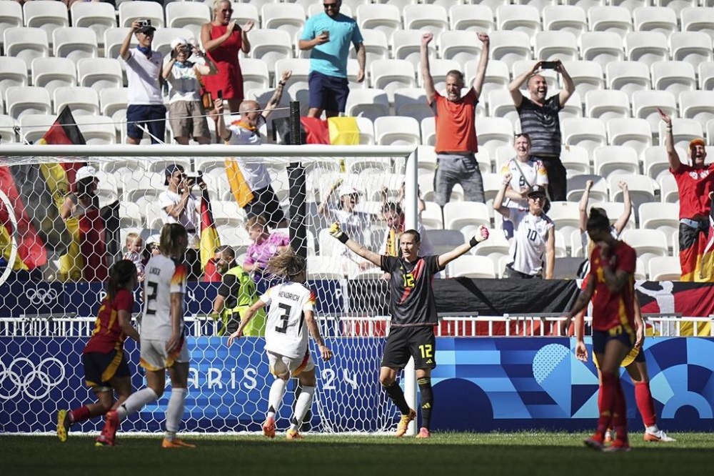 Germany's goalkeeper Ann-Katrin Berger, center, celebrates after stopping a penalty by Spain's Alexia Putellas during the women's bronze medal soccer match between Spain and Germany, at the Lyon stadium, during the 2024 Summer Olympics, Friday, Aug. 9, 2024, in Decines, France. (AP Photo/Laurent Cipriani)