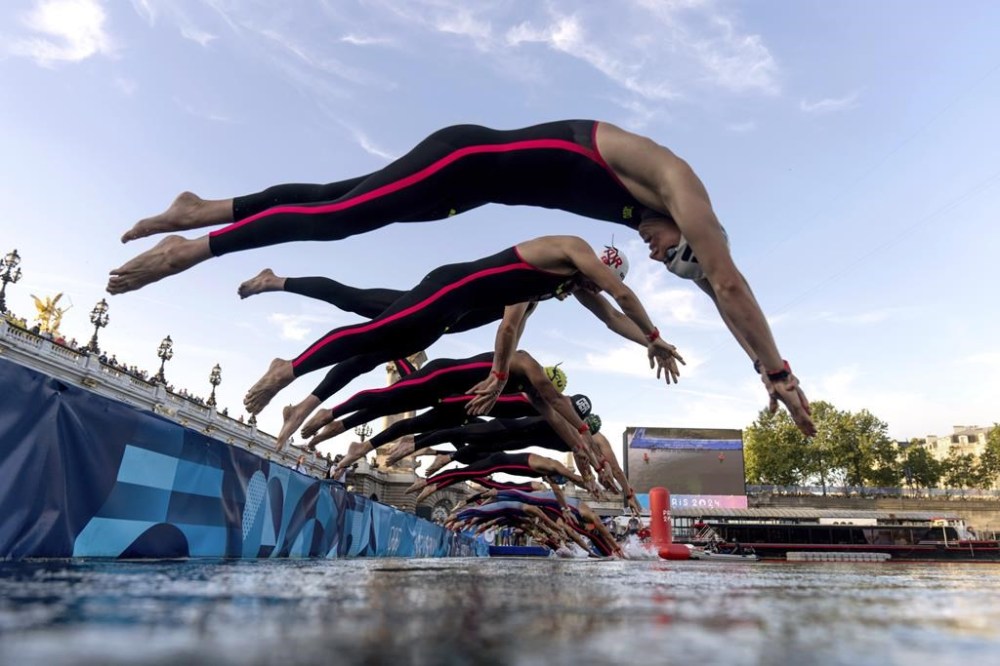 Competitors dive into the Seine river for the start of the marathon swimming men's 10km, at the 2024 Summer Olympics, Friday, Aug. 9, 2024, in Paris, France. (AP Photo/David Goldman, Pool)