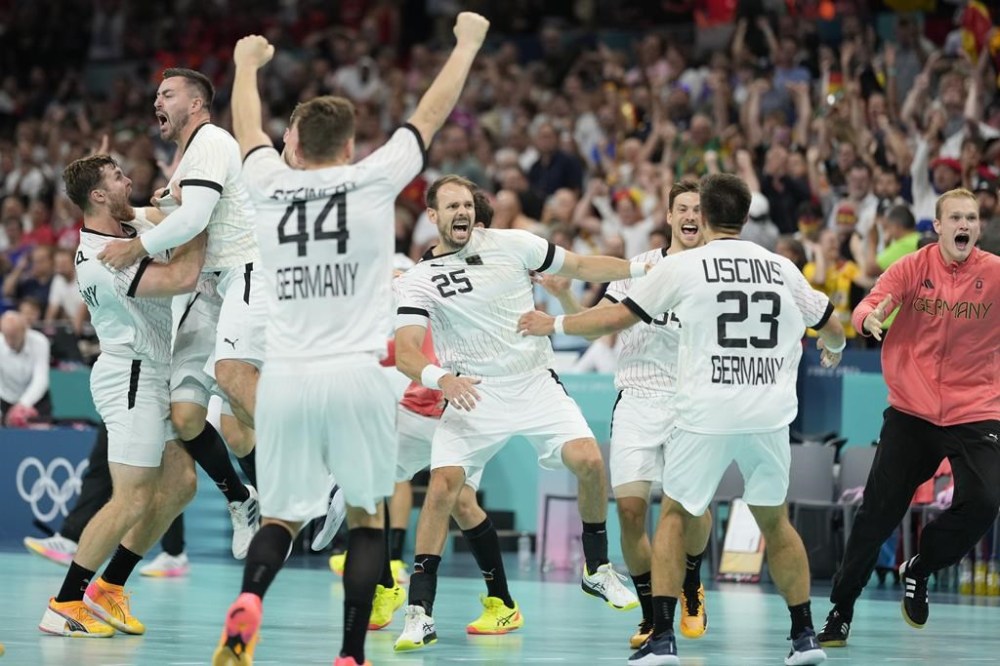 Germany players celebrate their victory after a semifinal handball match between Germany and Spain at the 2024 Summer Olympics, Friday, Aug. 9, 2024, in Villeneuve-d'Ascq, France. (AP Photo/Aaron Favila)