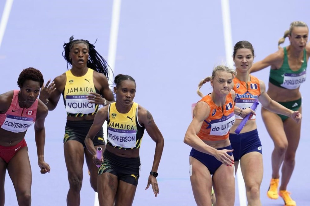 Stephenie Ann McPherson, of Jamaica, and Lisanne de Witte, of the Netherlands, compete in a women's 4 x 400 meters relay round 1 heat at the 2024 Summer Olympics, Friday, Aug. 9, 2024, in Saint-Denis, France. (AP Photo/Ashley Landis)