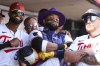 Minnesota Twins' Carlos Santana, center, celebrates his solo home run with teammates Willi Castro, left, and Christian Vázquez, right, in the dugout during the second inning of the first game of a baseball doubleheader against the Cleveland Guardians, Friday, Aug. 9, 2024, in Minneapolis. (AP Photo/Matt Krohn)