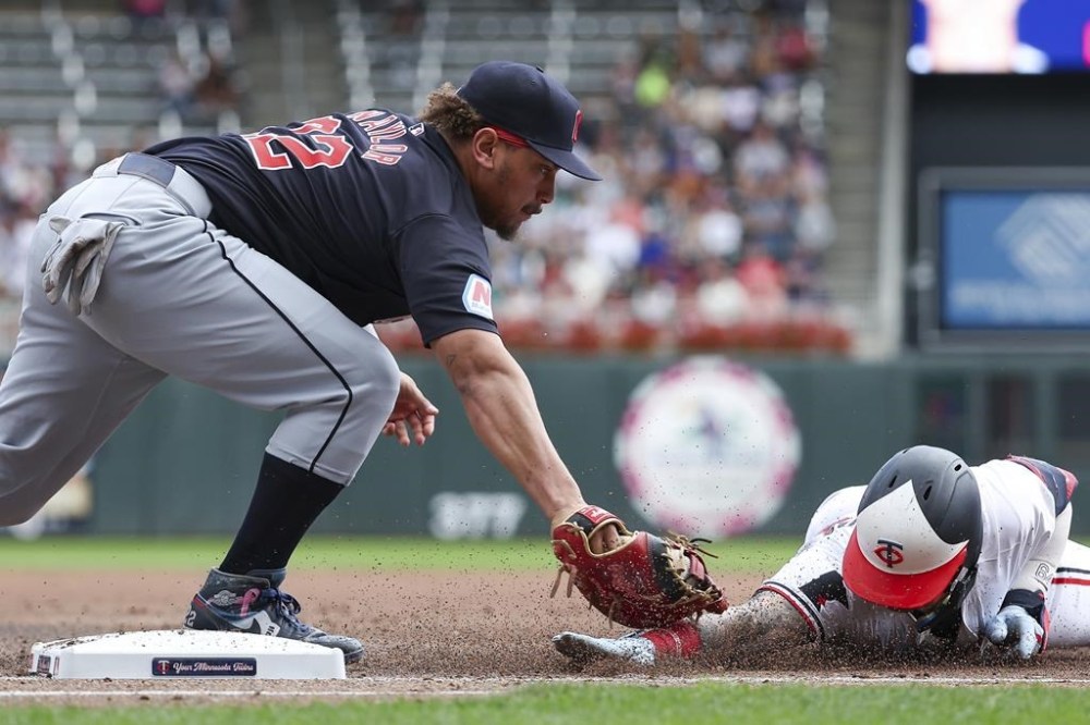 Cleveland Guardians first baseman Josh Naylor, left, tags out Minnesota Twins' Jose Miranda at first base during the first inning of the first game of a baseball doubleheader, Friday, Aug. 9, 2024, in Minneapolis. (AP Photo/Matt Krohn)